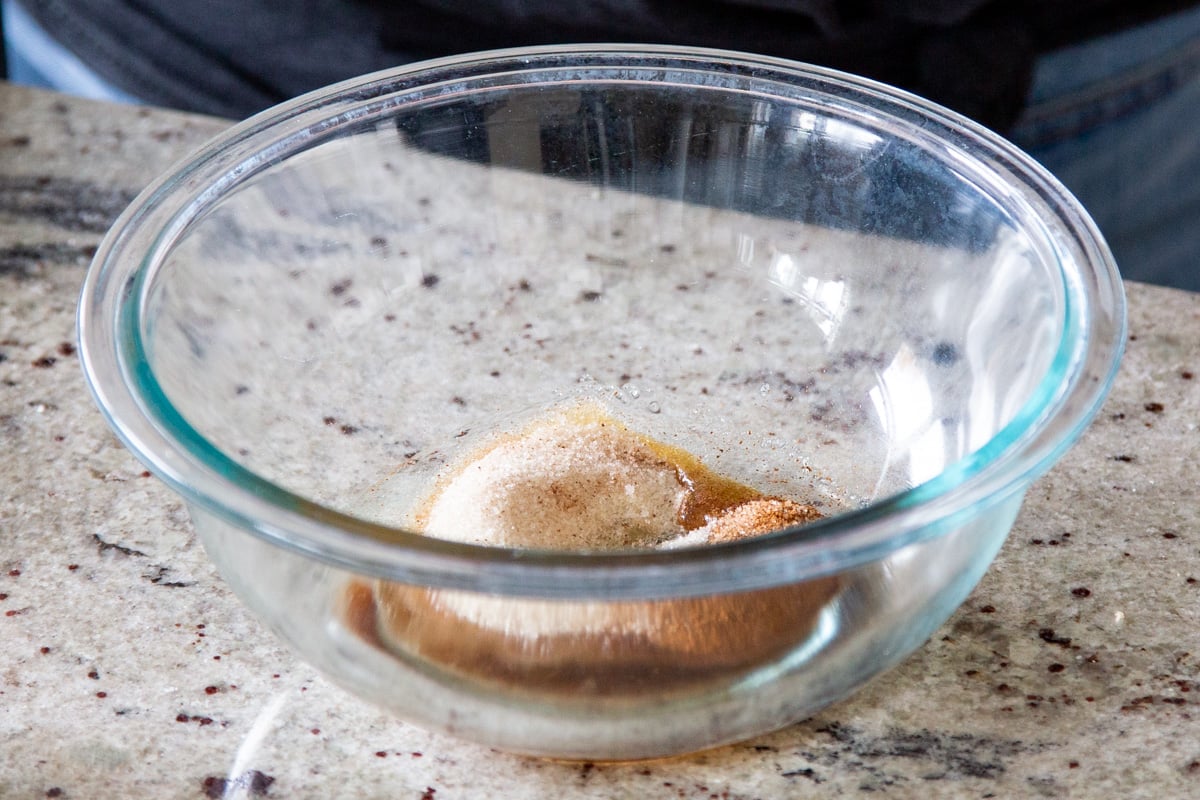 a glass bowl with cinnamon, sugar and maple syrup