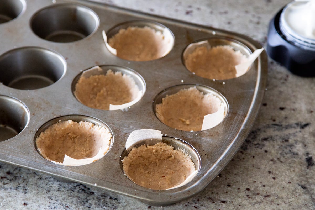 a muffin tin with 6 vegan pastry crusts ready for baking