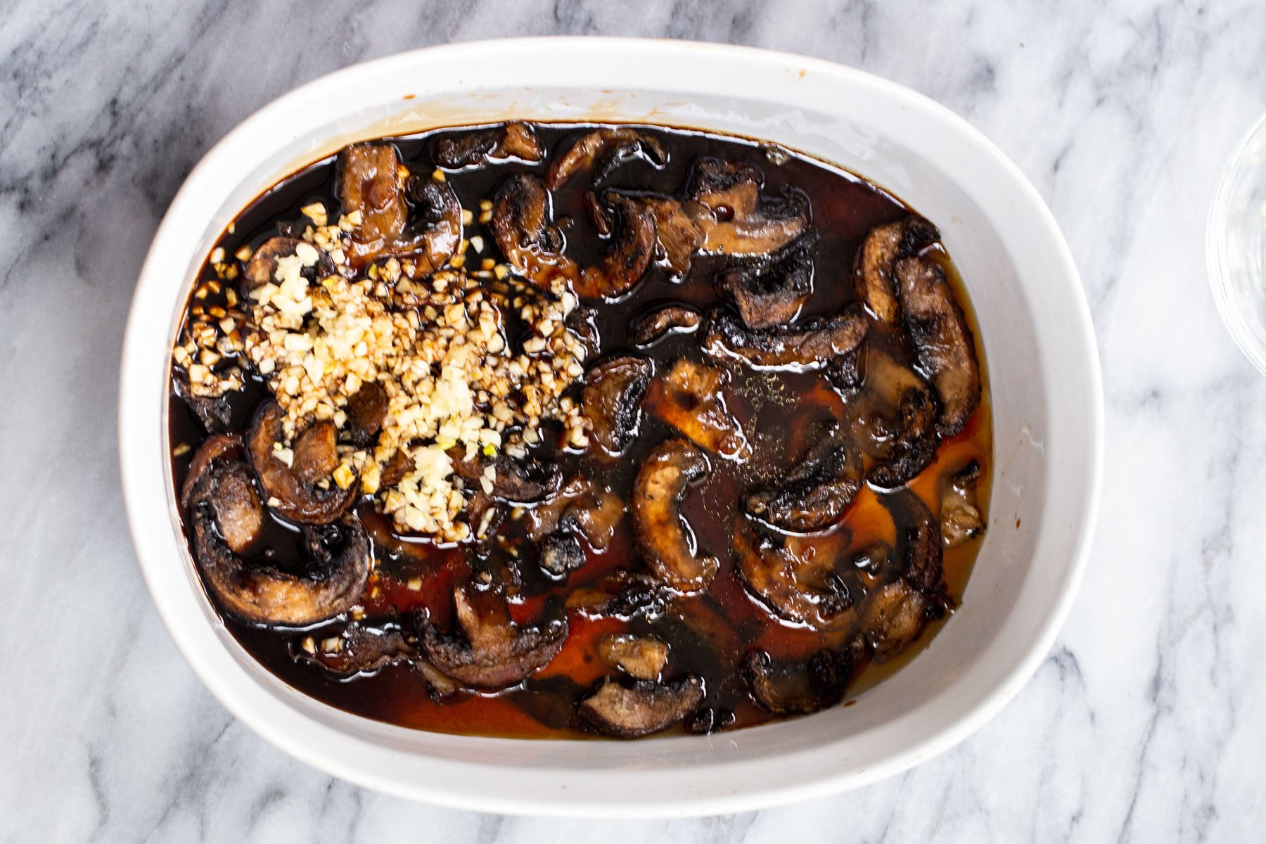 mushroom slices tossed in sweet and salty sauce in a casserole dish