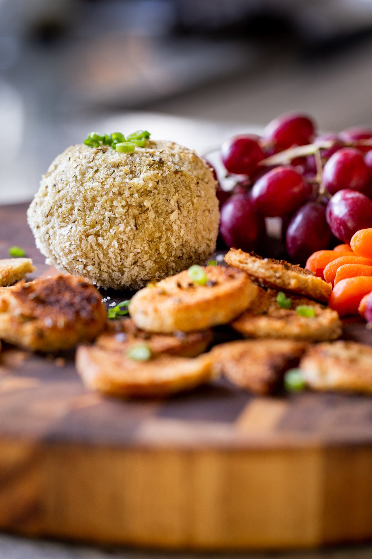 side view of a vegan charcuterie board with grapes, crackers and carrots