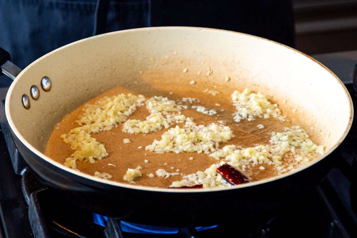 minced garlic, dried chili and ginger sauteeing in a frying pan