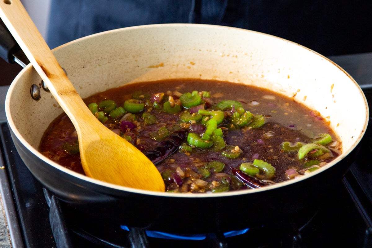 celery and onion in a saucepan with soy sauce and maple syrup