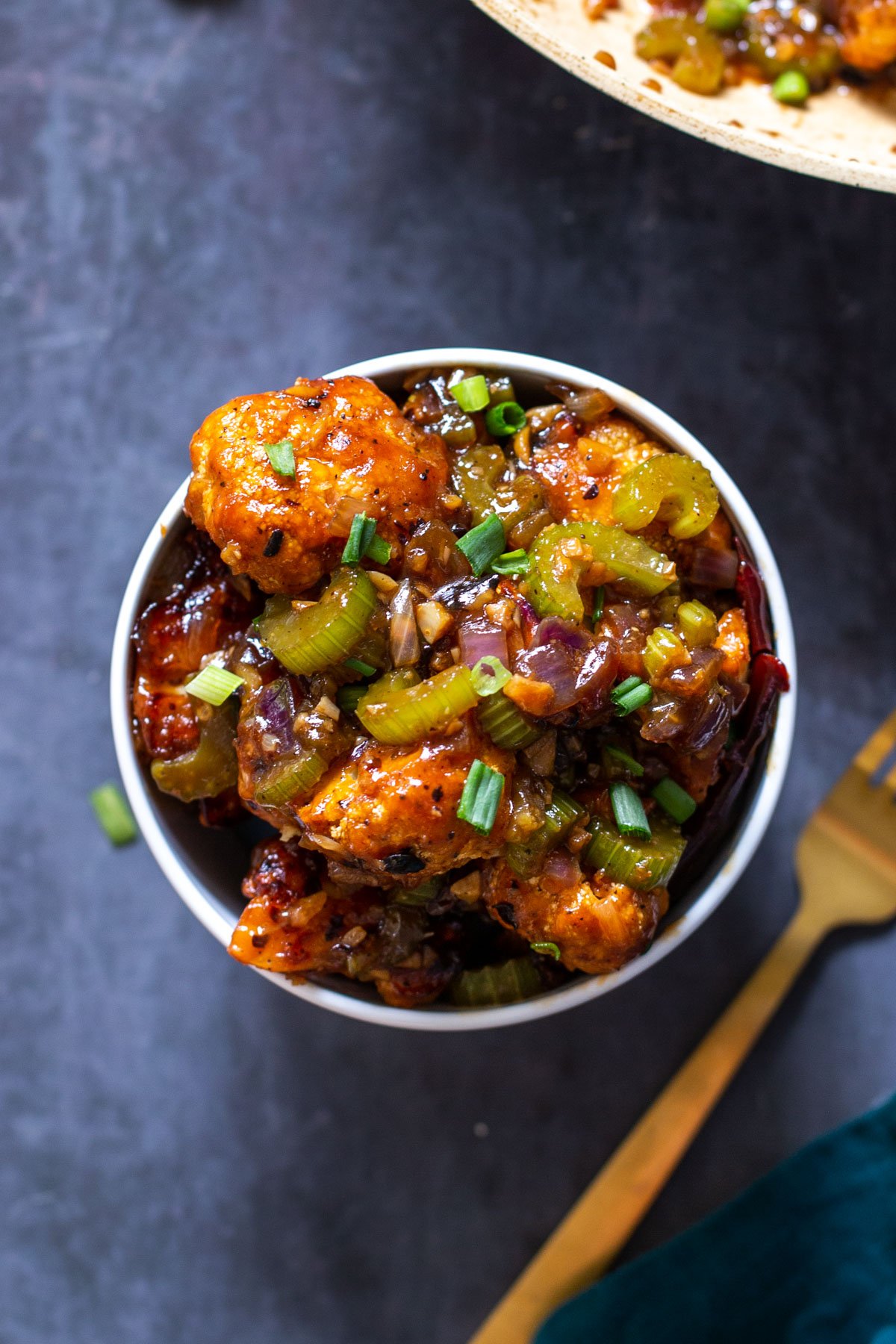 overhead shot of a bowl with sweet and spicy black pepper cauliflower