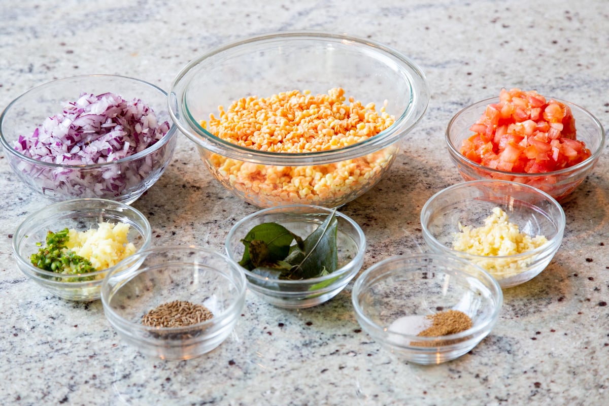 ingredients for making caramelized onion dal on a marble countertop