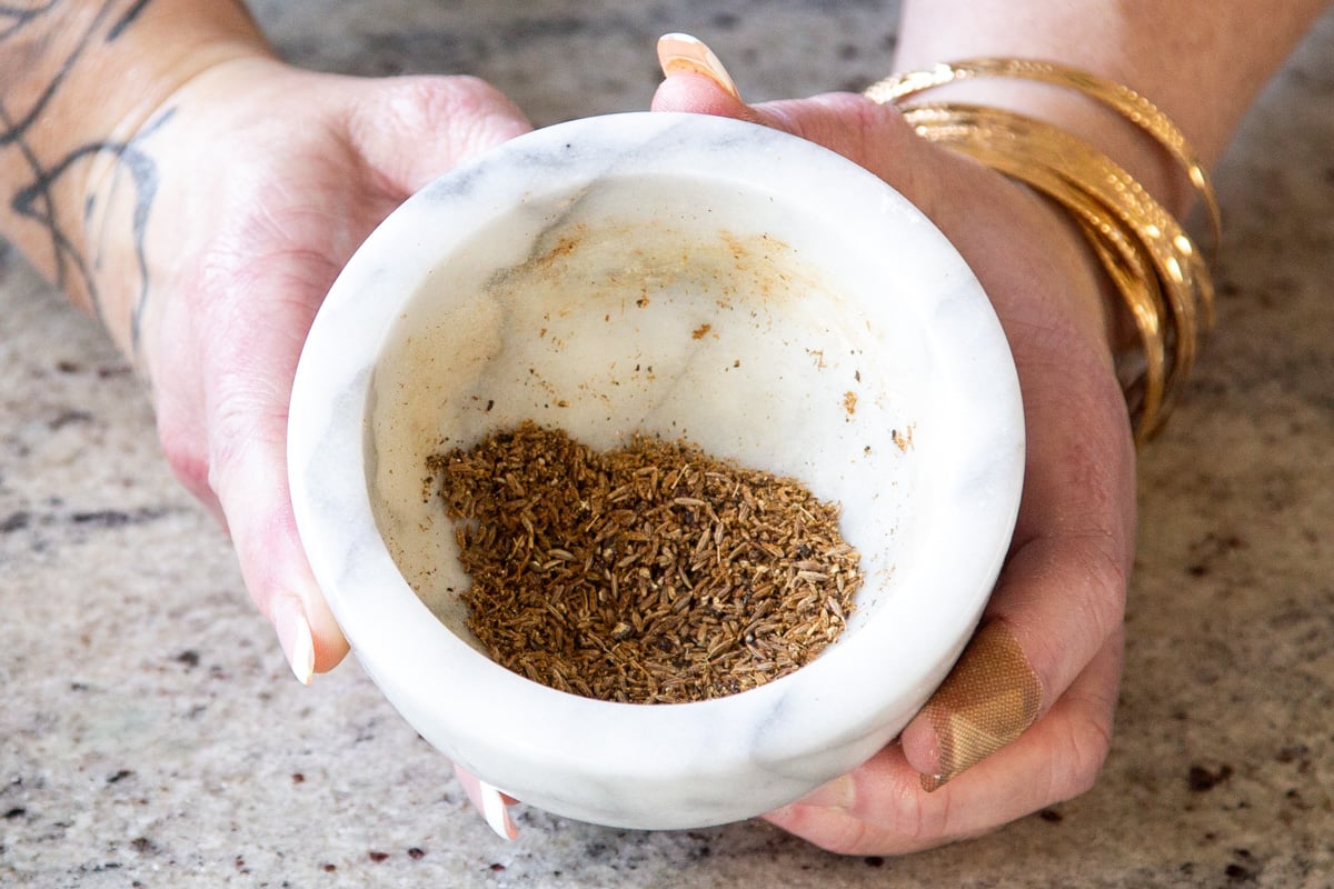 cumin and peppercorn in a marble mortar