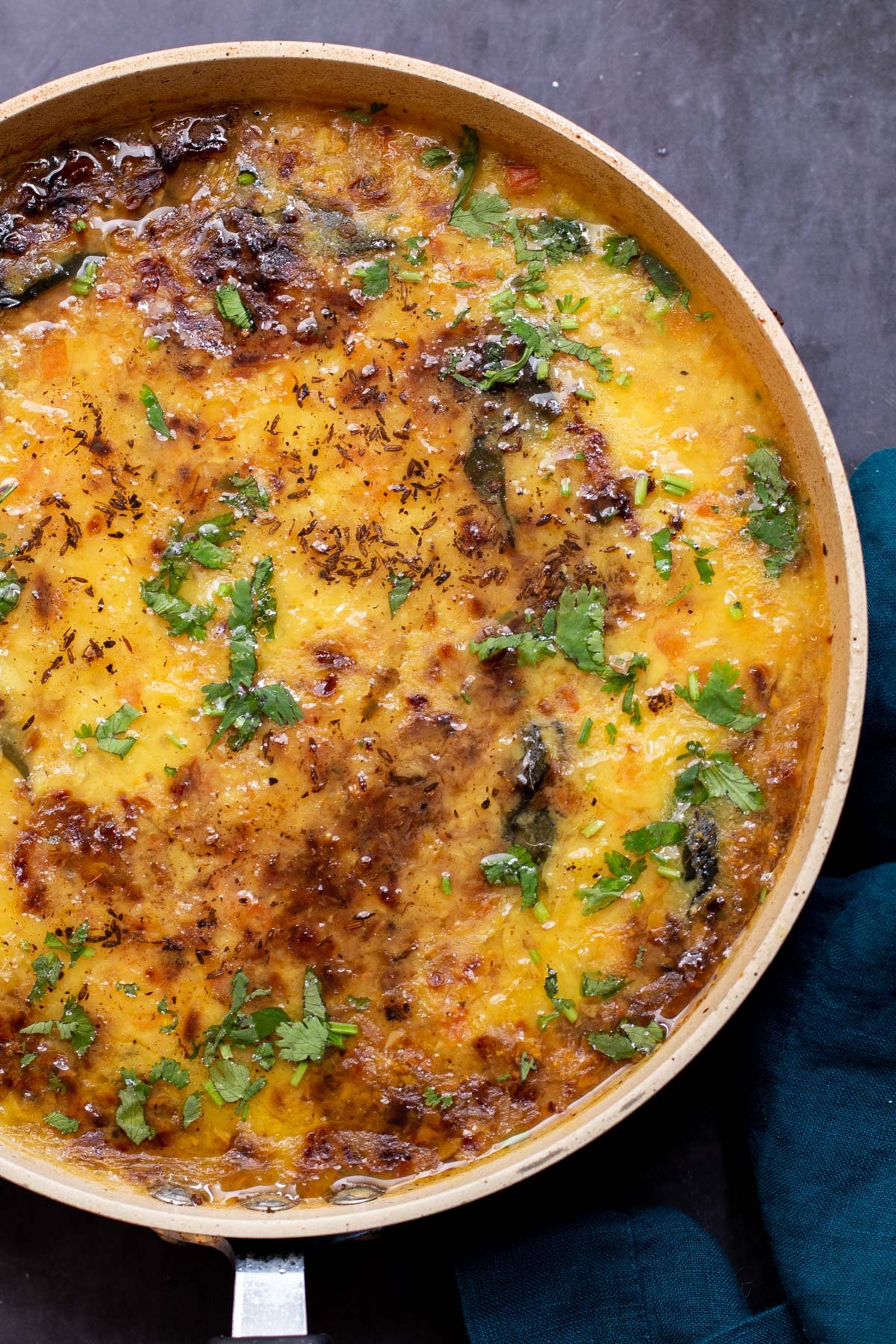 a frying pan with caramelized onion dal sprinkled with chopped cilantro