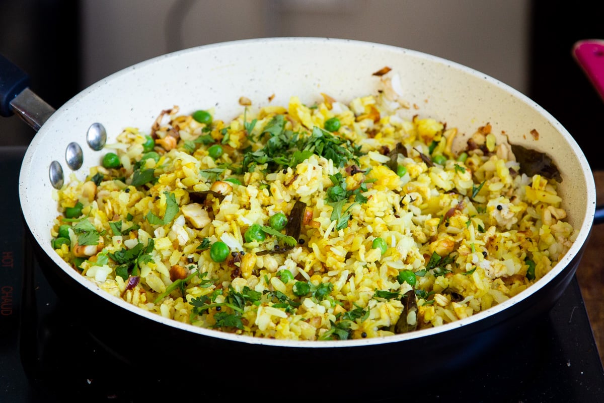 a pan with kanda poha sprinkled with chopped cilantro