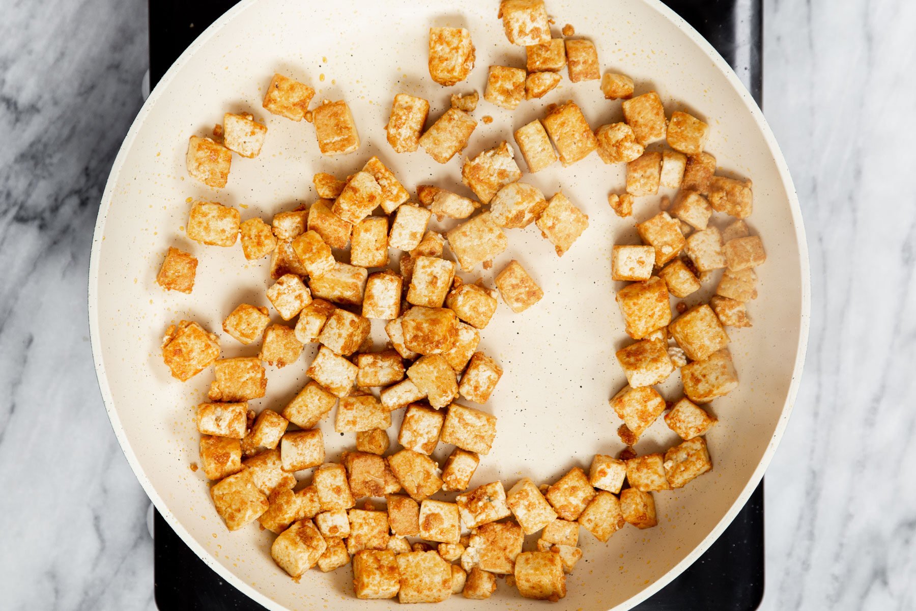 pan-fried tofu cubes in a pan 