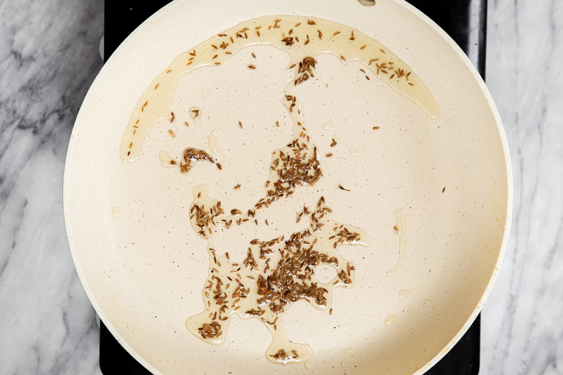 cumin seeds tempering in a pan 