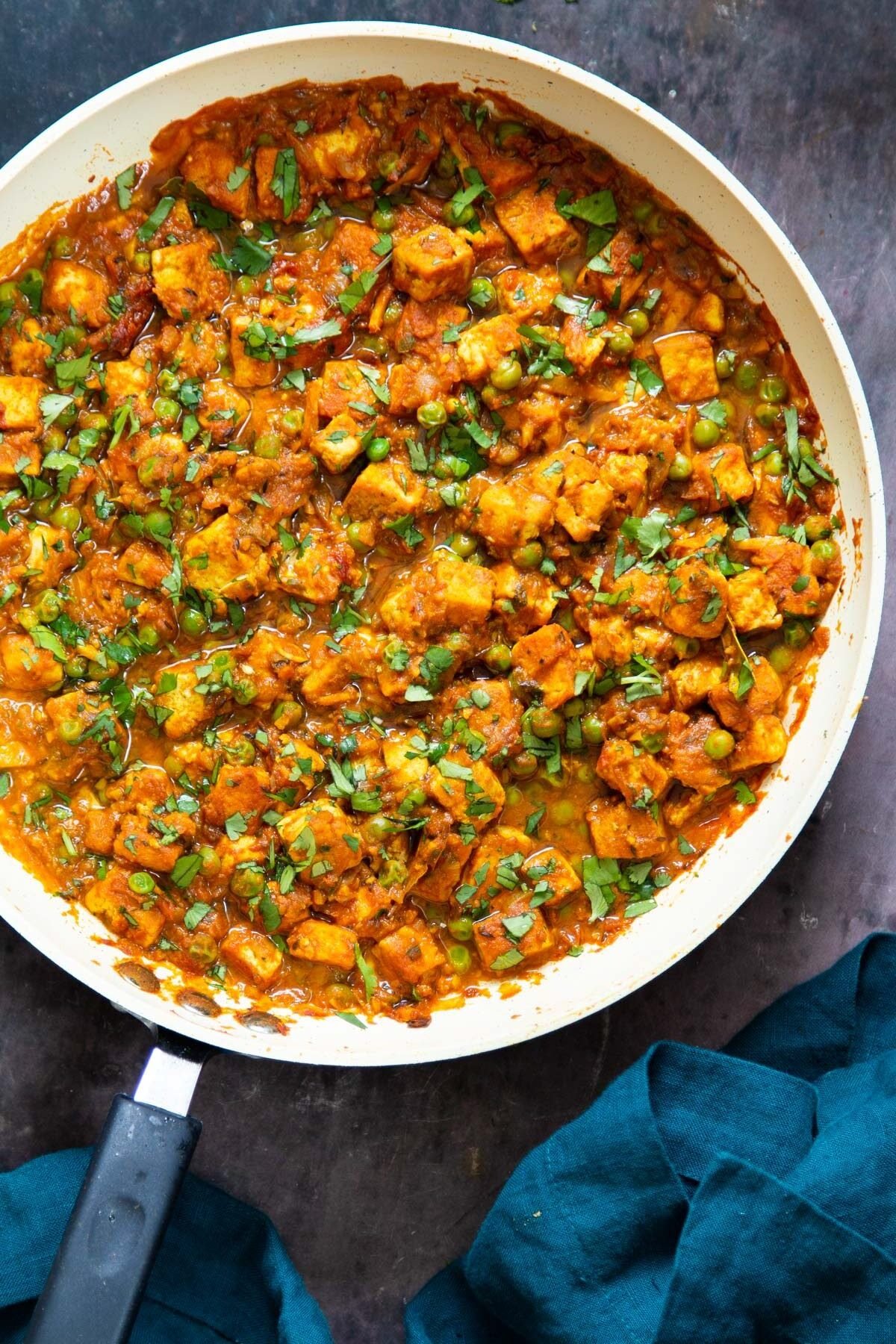 Indian tofu curry in a sauteeing pan sprinkled with cilantro 