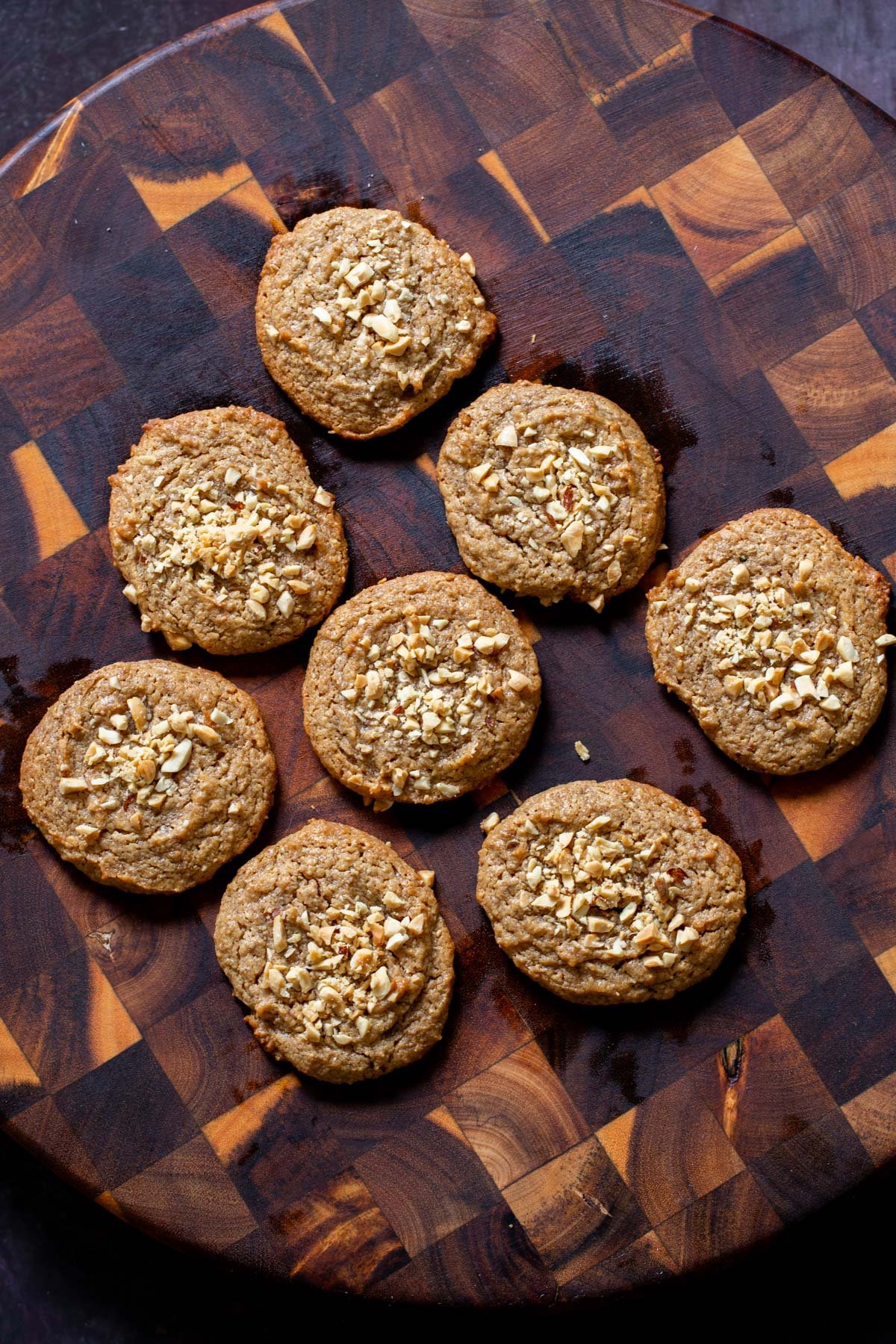 no flour vegan peanut butter cookies on a board topped with crushed peanuts