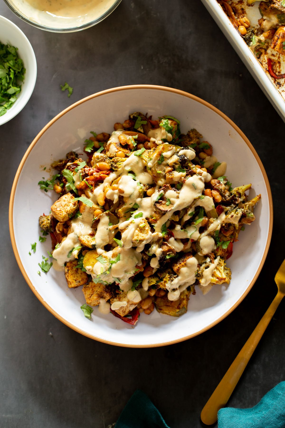 a plate with berbere sheet pan veggies drizzled with tahini dressing