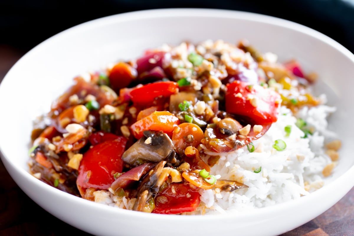 side view of a bowl of Indo Chinese veggies in hot garlic sauce served with rice