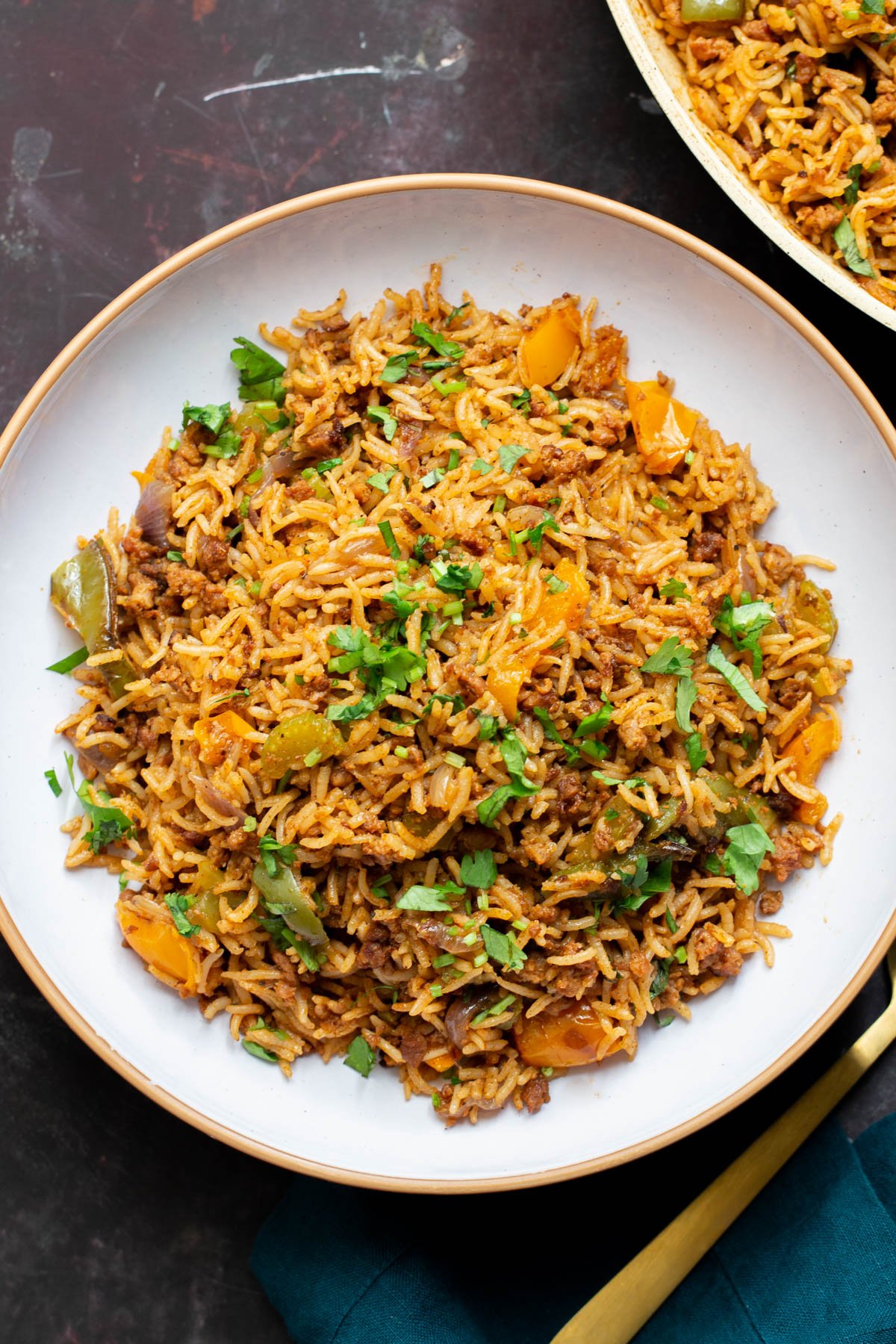 overhead shot of a plate with vegan dirty rice topped with chopped cilantro leaves