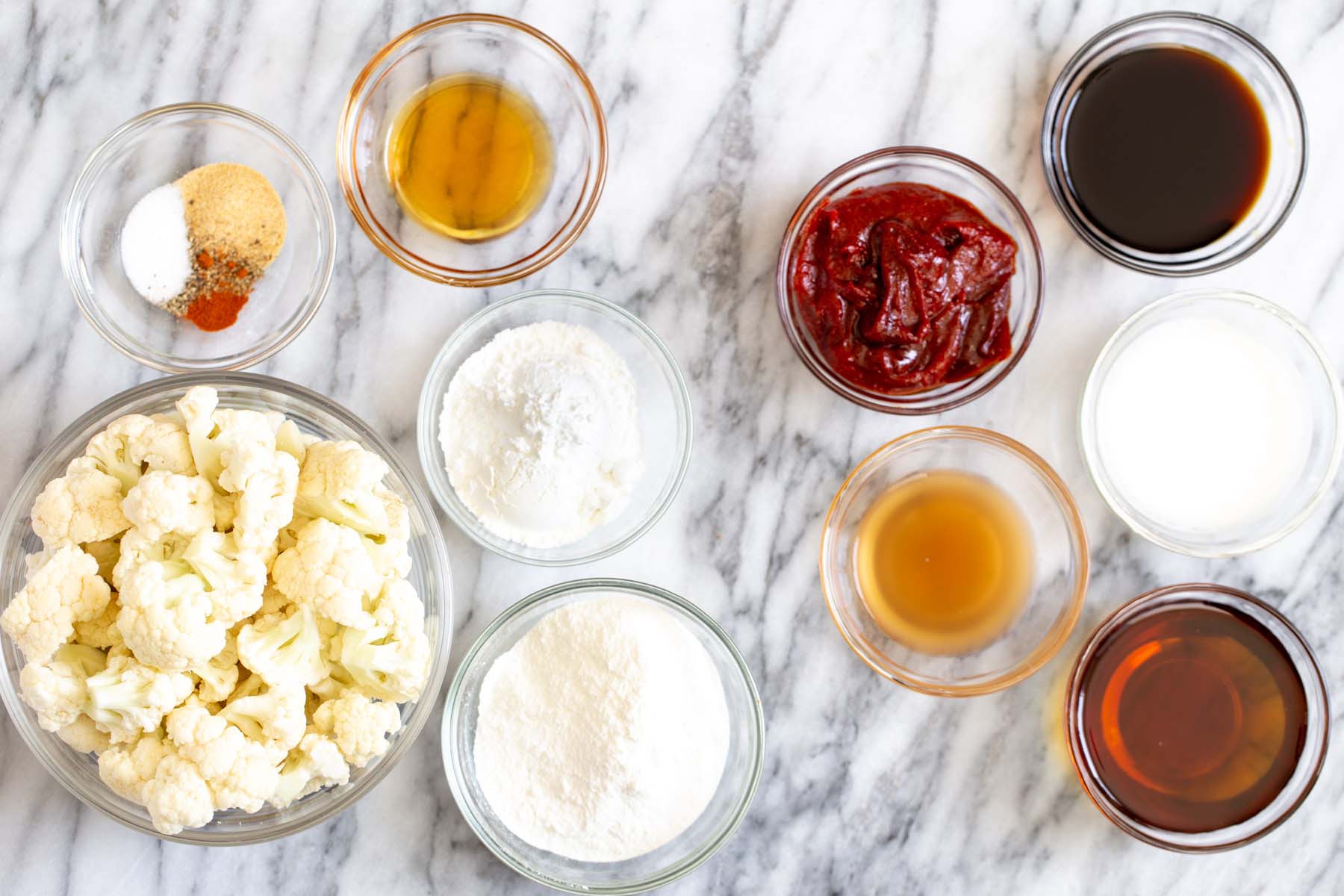 gochujang cauliflower ingredients in bowls on a marble table