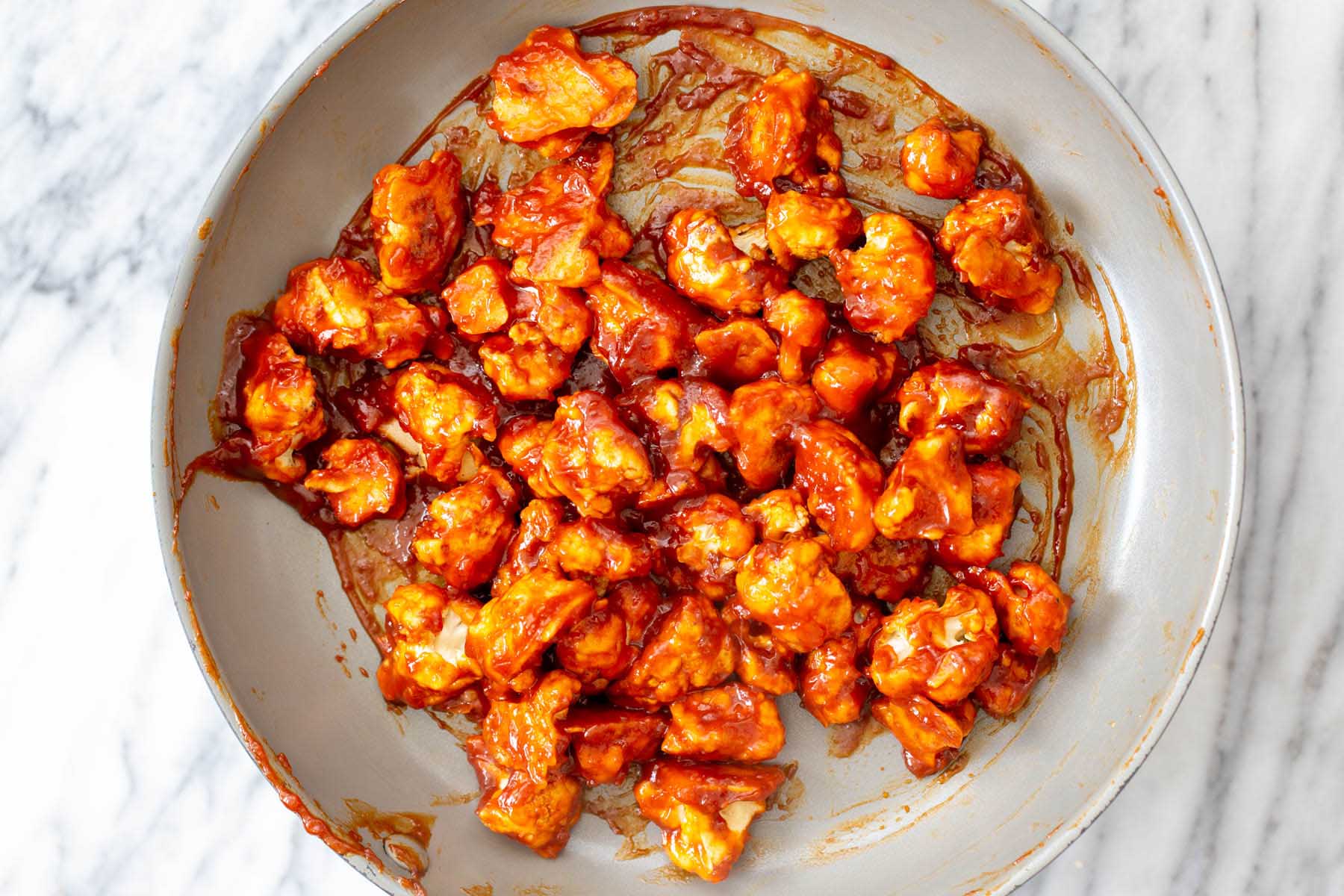 cauliflower tossed in gochujang sauce in the pan