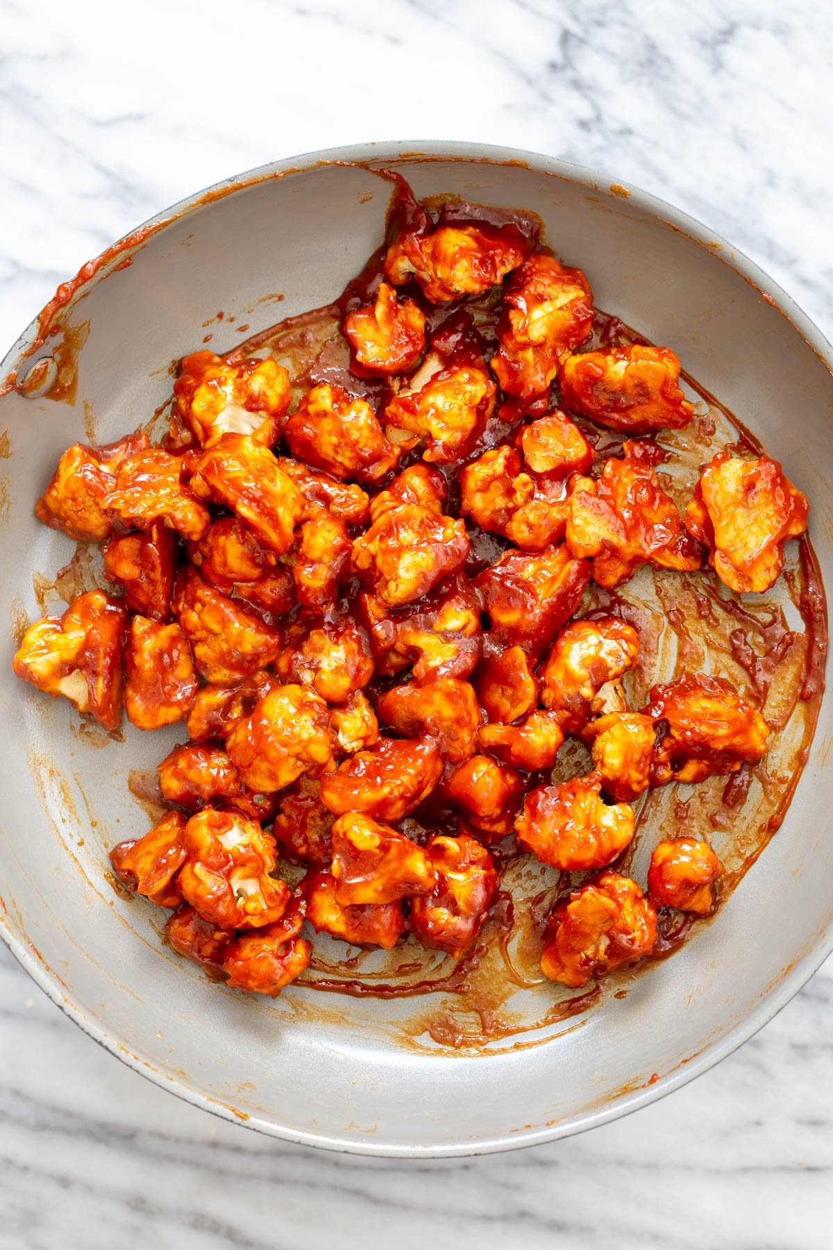 cauliflower tossed in gochujang sauce in the pan