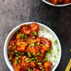 gochujang cauliflower wings in bowls with rice and green onions