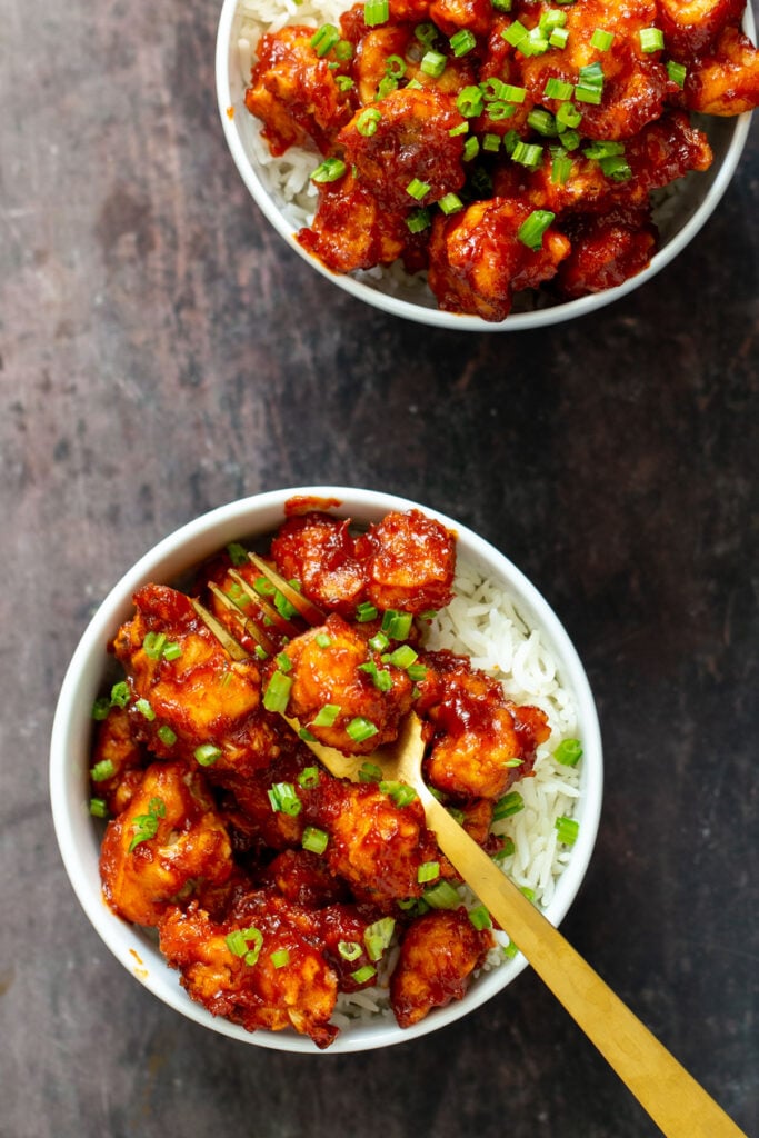 gochujang cauliflower wings in bowls with rice and green onions