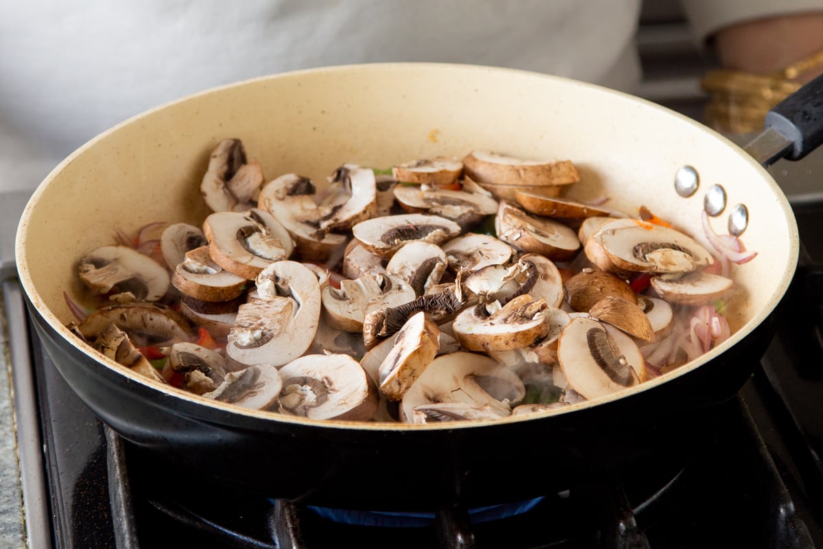 sliced mushrooms in a sauteeing pan