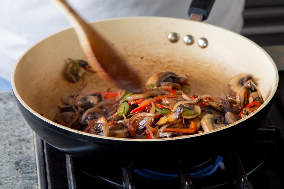 sauteed mushrooms and bell peppers in a sauteeing pan