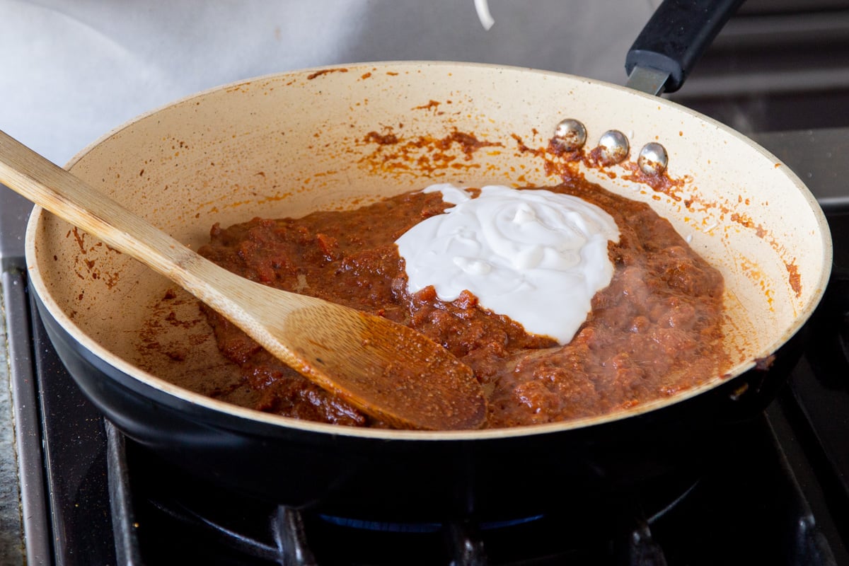 a dollop of vegan yogurt being added to a frying pan