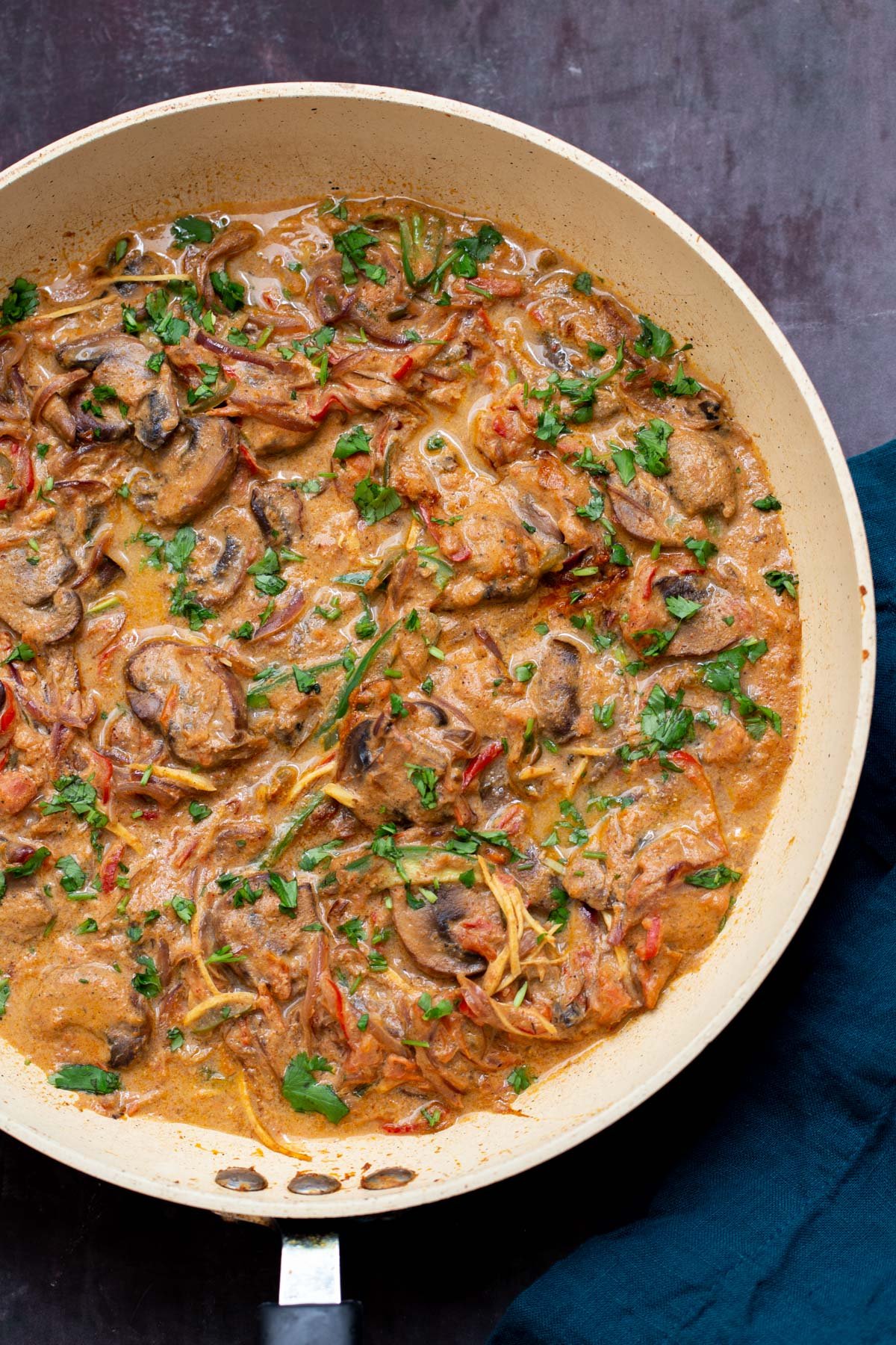 a saucepan with vegan mushroom patiala sprinkled with chopped herbs