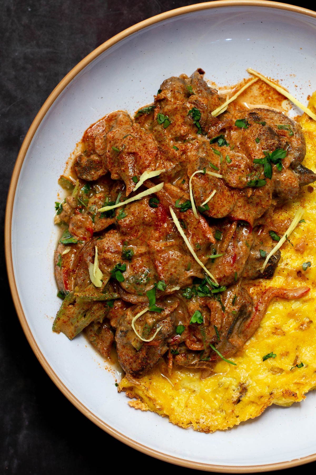 plated serving of vegan patiala with mushrooms served alongside a folded vegan omelet