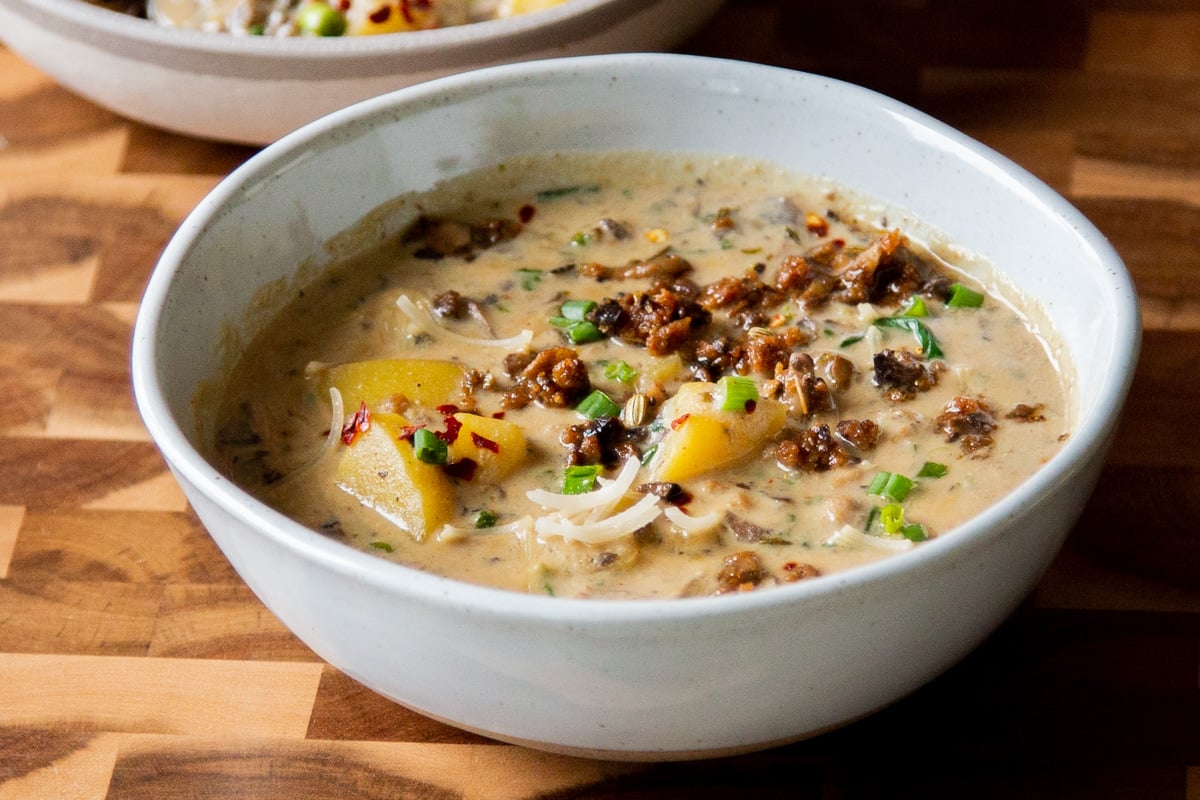 a bowl of vegan zuppa toscana topped with veggie crumbles