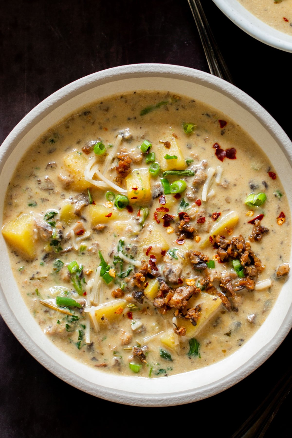 overhead shot of a bowl of creamy vegan zuppa toscana topped with chopped chives