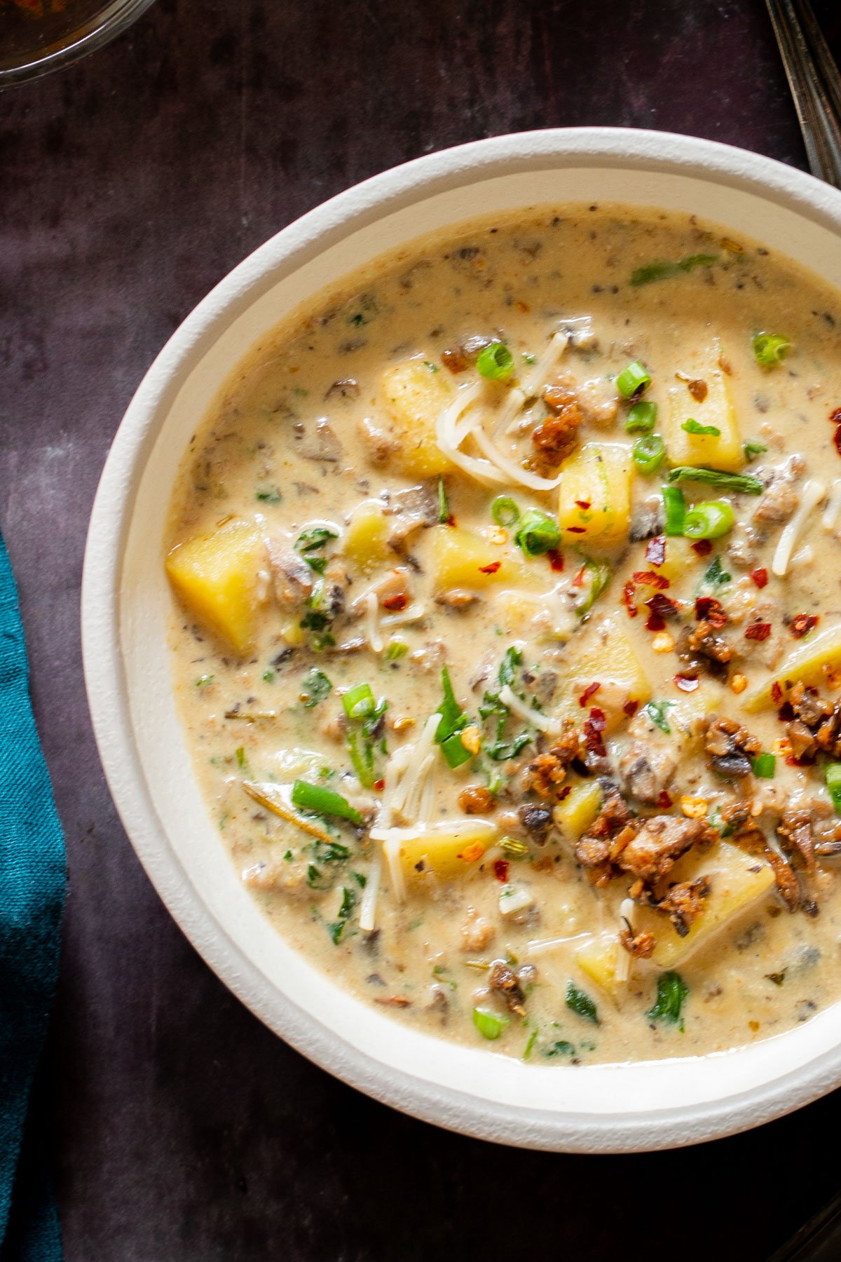a plate of vegan zuppa toscana topped with chopped chives