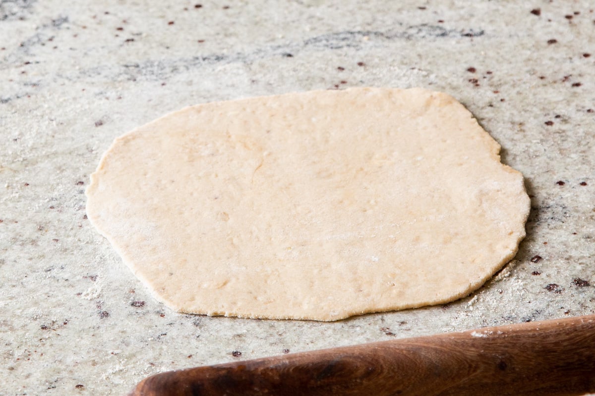 paratha dough rolled out on a lightly oiled countertop