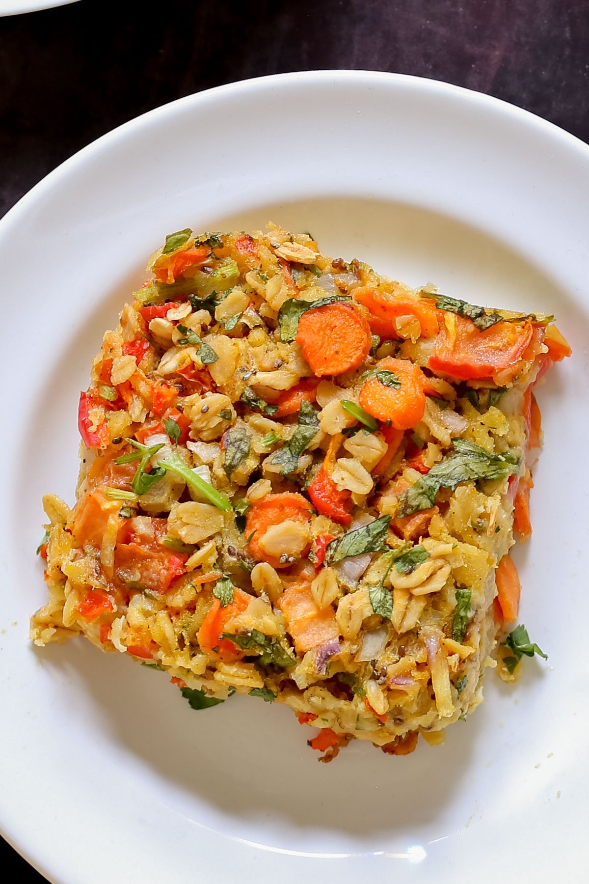 close-up of a piece of savory baked oatmeal on a white plate