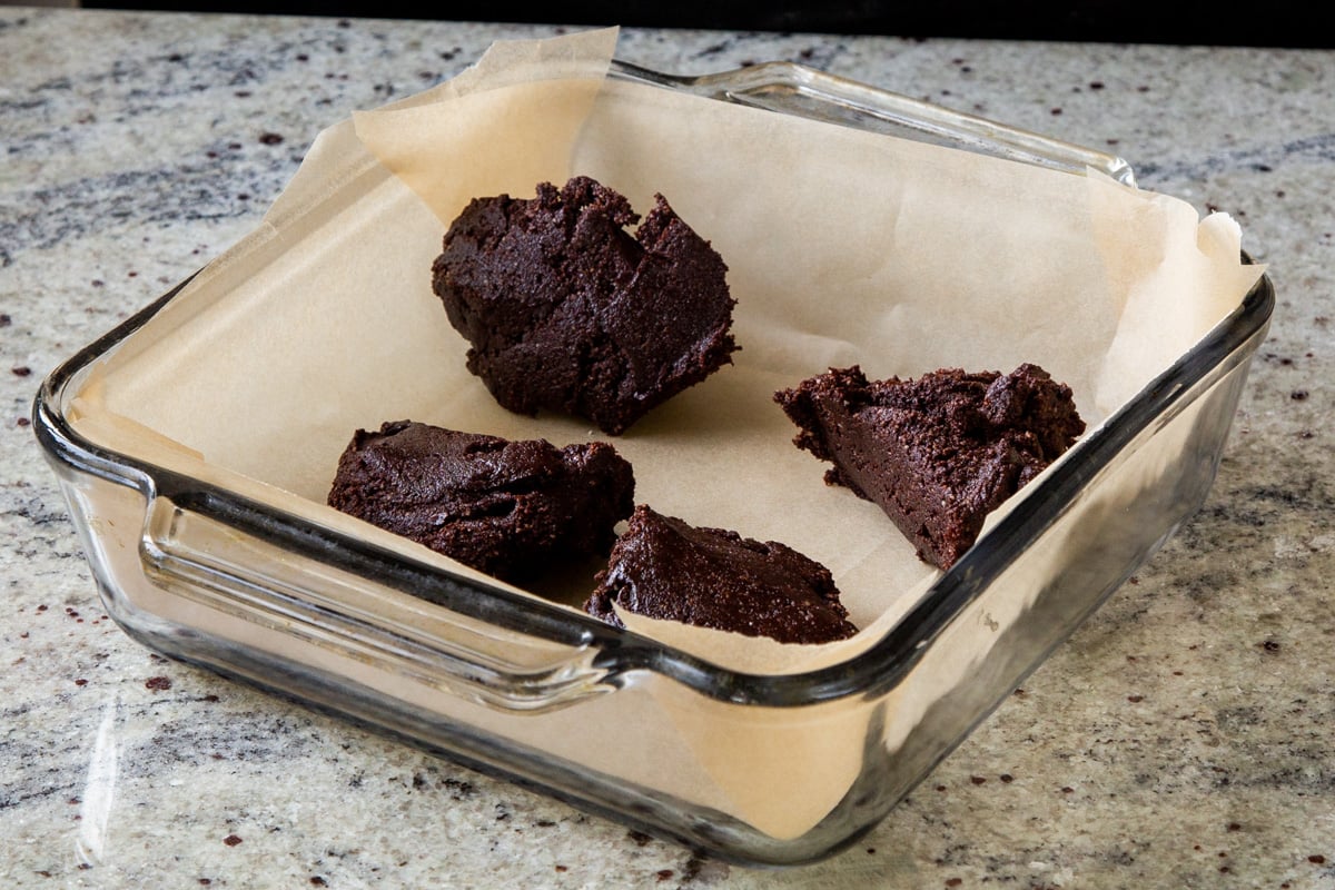 pieces of brownie batter in the lined baking pan