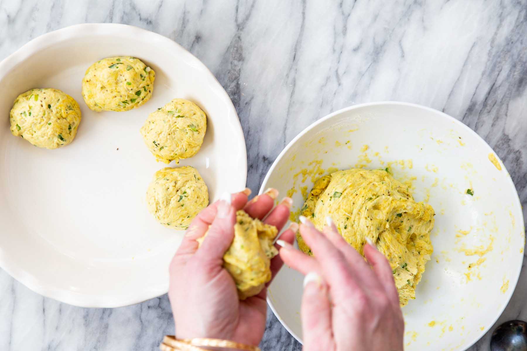 hands forming dough into balls