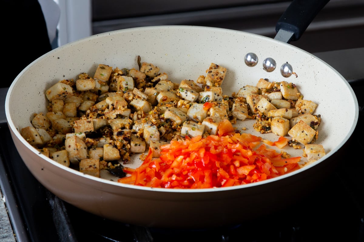 adding veggies to the pan of tofu and podi