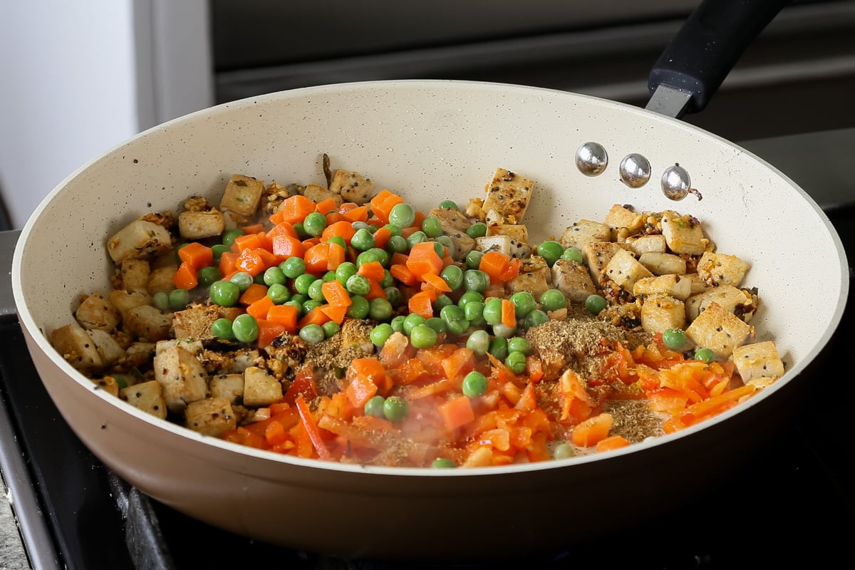 adding peas and carrots to the pan