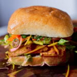 gochujang tofu banh mi with pickled veggies on a wooden cutting board