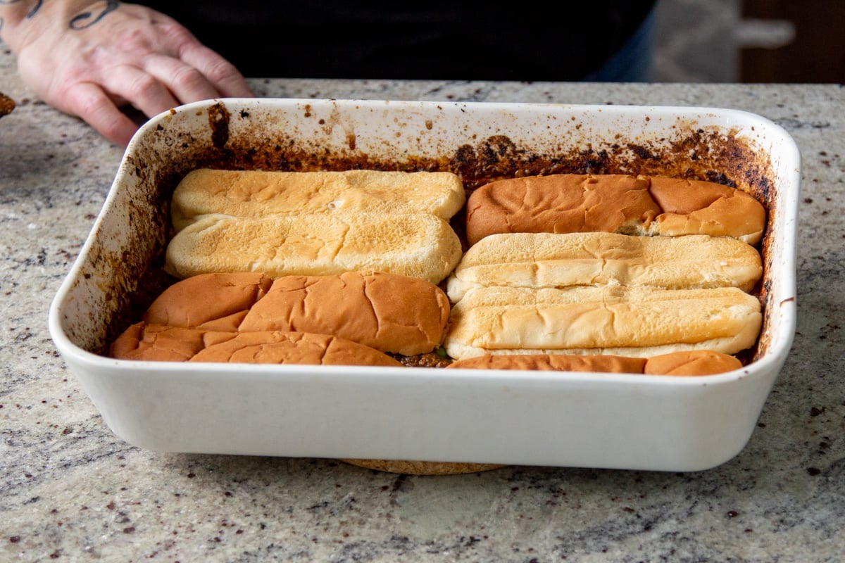 hot dog buns placed on top of the lentils in the baking pan
