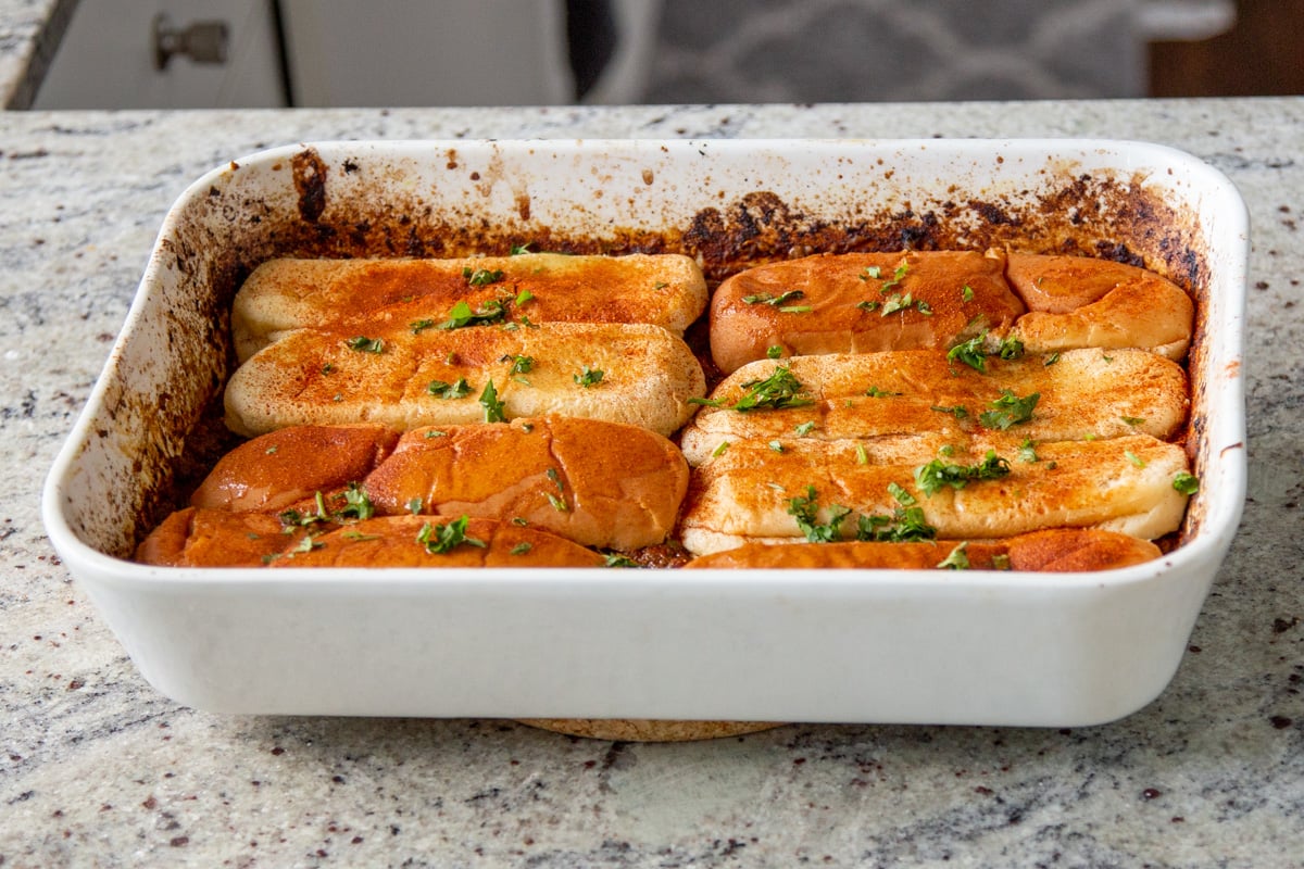 hot dog buns sprinkled with cilantro and lemon in the pan before baking