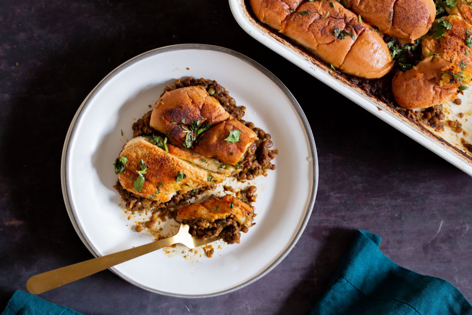 Lentil Keema Pav Casserole on the plate with a bite taken out
