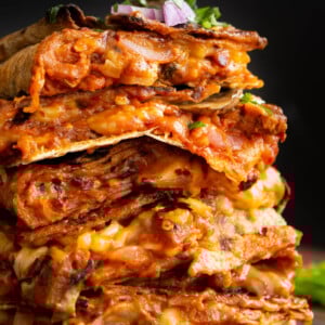 stack of vegan pizza quesadilla slices on a wooden cutting board