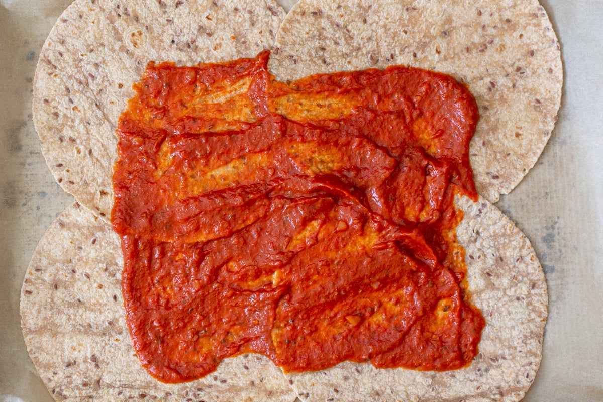pizza sauce spread onto the tortillas