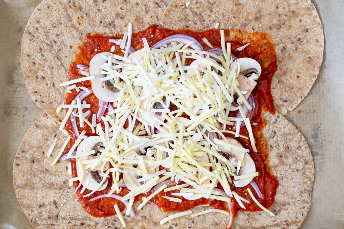 topping the veggies with vegan cheese