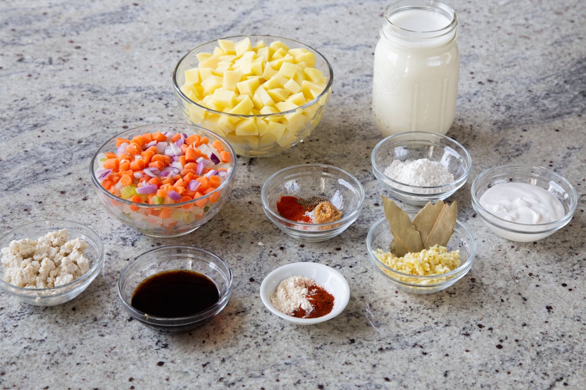 potatoes, veggies, and seasonings in containers on a kitchen countertop