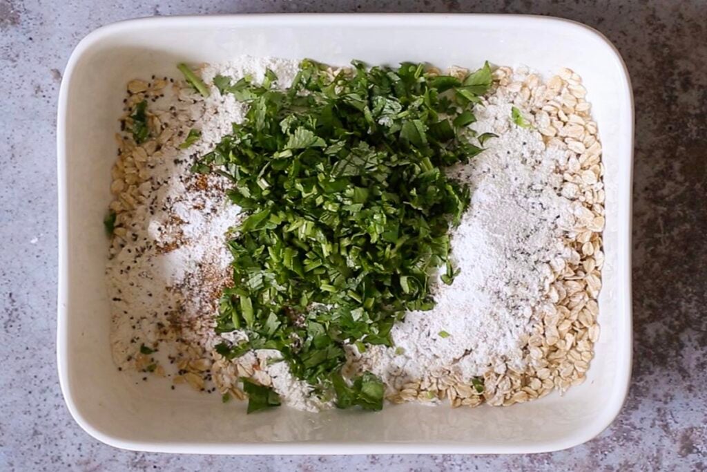 oats, flour, seeds, and cilantro in the baking pan before mixing