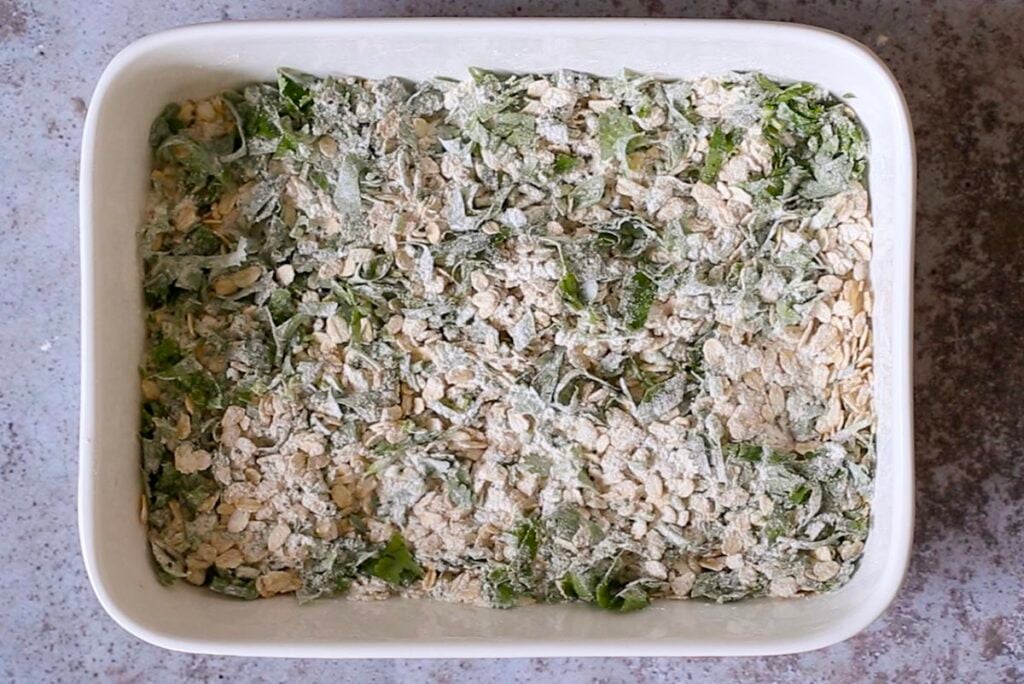 oats, flour, seeds, and cilantro in the baking pan after mixing