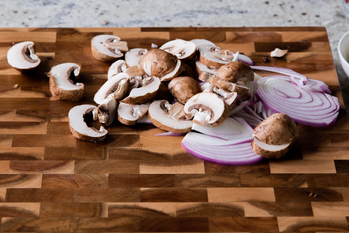 prepped mushrooms and onions on the cutting board
