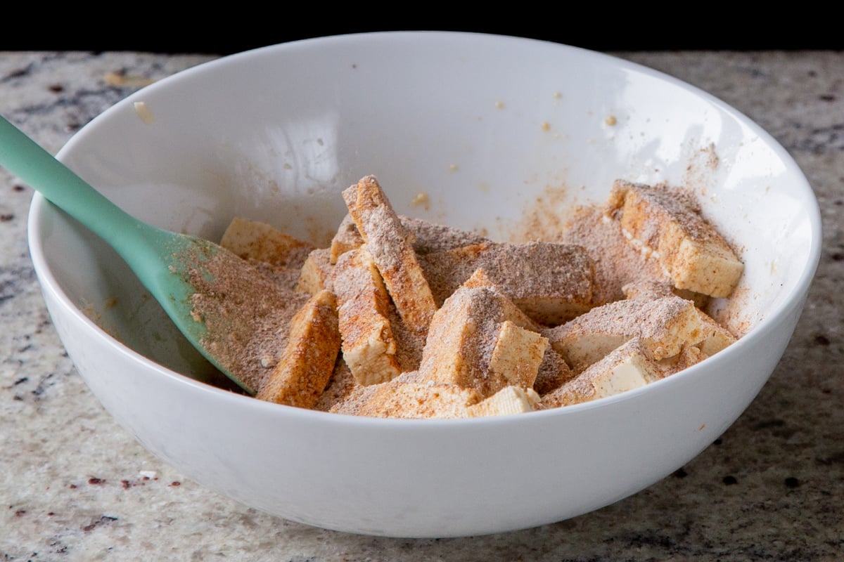 adding spices to the tofu pieces