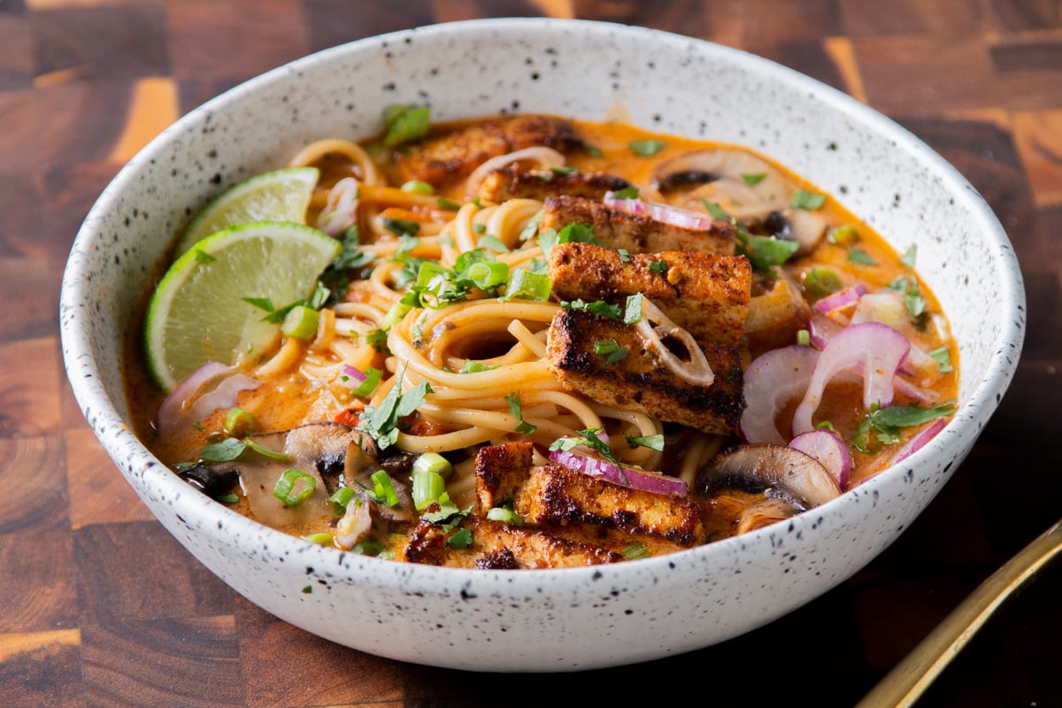 bowl of butter ramen with tofu and a lime wedge